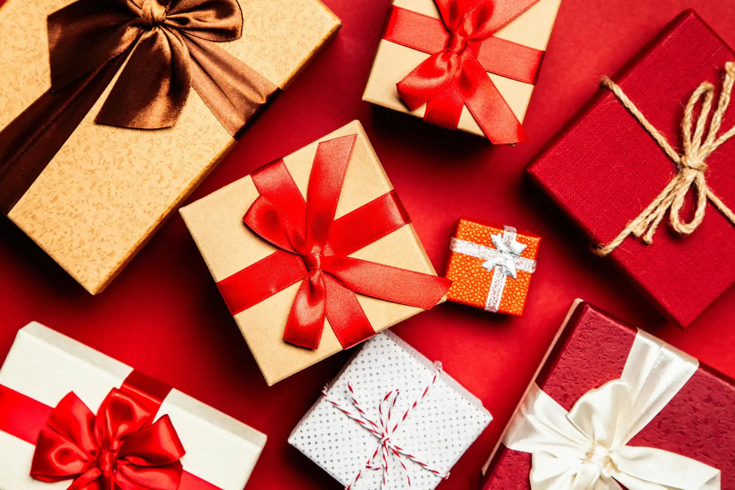 Assorted gift boxes with ribbons on a red background