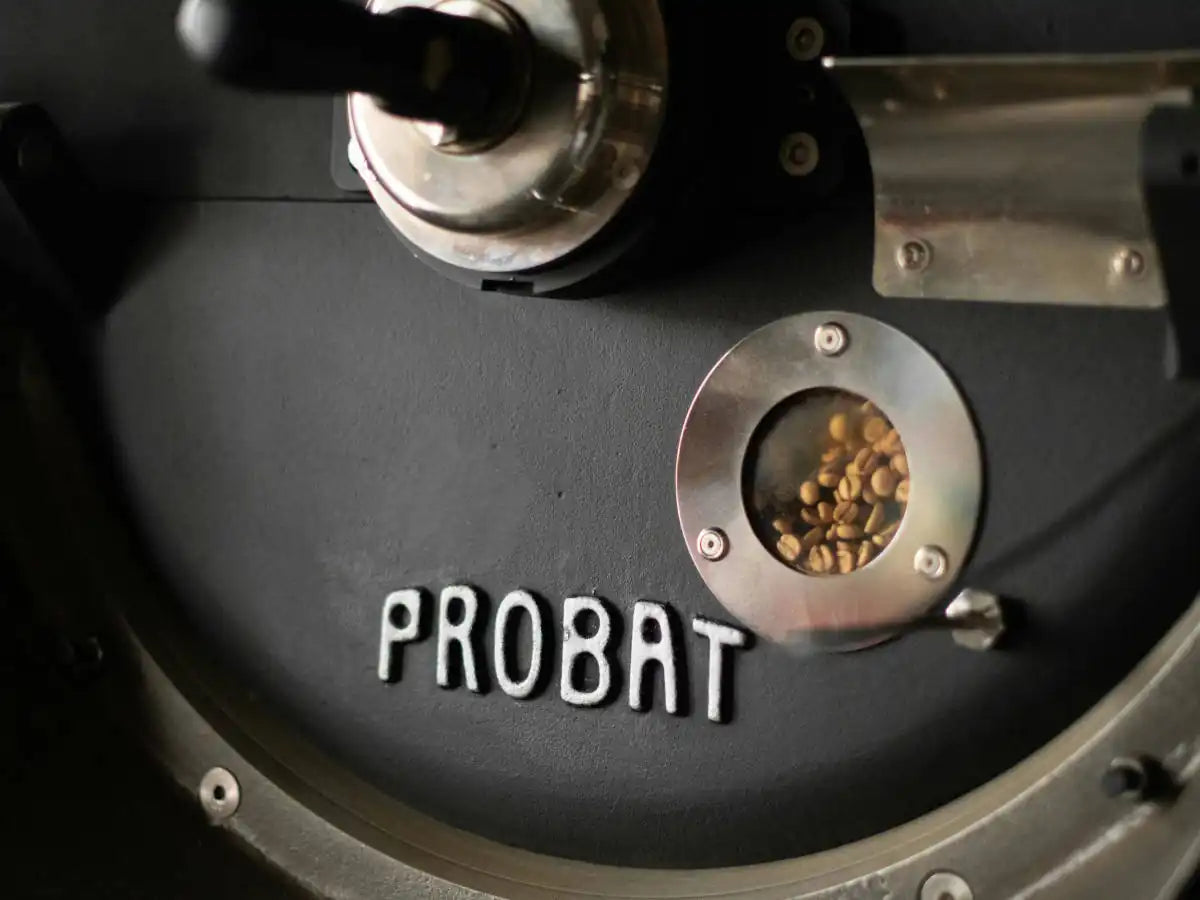 Close-up of a Probat coffee roaster with beans inside.