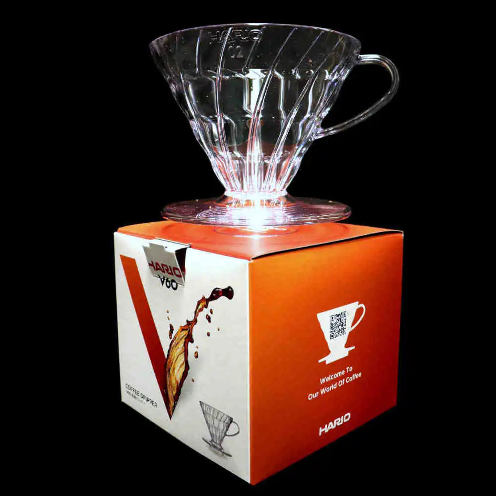 Clear glass Hario V60 coffee dripper on a branded box with a black background